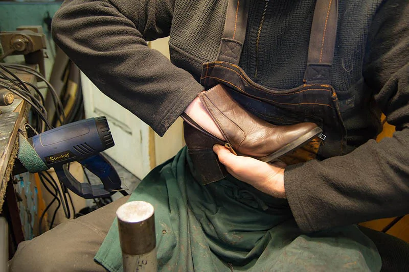 a man repairing an old shoe