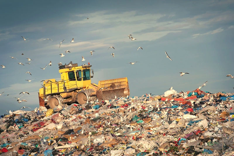 a yellow truck on a landfill